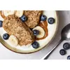 A close-up shot of a bowl of cereal with yogurt, banana slices, blueberries, and a spoon. Anteprima dell’immagine prodotto