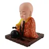 A solar-powered wackelfigur (wobble figure) of a meditating Buddha monk. Produktbild-Vorschau