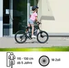 A young girl is riding a bicycle in front of a building. Produktbild-Vorschau
