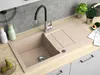 A kitchen sink area with a beige granite sink, faucet, and countertop. There are also decorative items like bottles, plants, and avocados. Produktbild-Vorschau