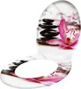 A toilet seat with a decorative print of stacked stones and a pink orchid. Produktbild-Vorschau
