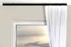 A black curtain rail mounted above a window with a white curtain partially drawn. Anteprima dell’immagine prodotto