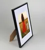A black picture frame with a photo of a woman and a child in a field. Produktbild-Vorschau