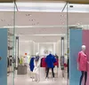 A storefront display of a clothing store with mannequins showcasing outfits. Voir les images du produit