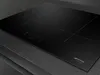 A close-up, angled view of a black induction cooktop. Voir les images du produit