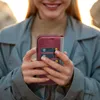 A person holding a phone with a wallet case. Produktbild-Vorschau
