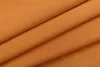 A close-up view of folded orange fabric, likely curtains, showing the texture and folds. Produktbild-Vorschau