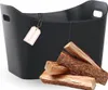 A black leather log basket with a tag and some firewood in front of it. Produktbild-Vorschau