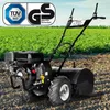 A black gasoline-powered garden tiller is shown in a field with green crops in the background. Produktbild-Vorschau