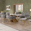 A dining room with a marble-topped table and six gray velvet chairs with gold legs. Produktbild-Vorschau