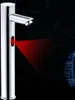 A chrome faucet with a red infrared sensor beam emanating from it, set against a dark background with faint circuit board graphics. Podgląd zdjęcia produktu