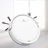 A white robot vacuum cleaner is shown in a studio setting with a bright window and sheer curtains in the background. Produktbild-Vorschau