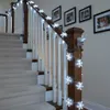 A string of snowflake-shaped LED lights decorates a staircase railing. Náhled obrázku produktu