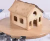 A gingerbread house made of cookies sits on a wooden board, surrounded by cookie cutters. Náhľad obrázku produktu