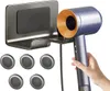 A hand holding a blue and gold hair dryer next to a gray wall-mounted holder. Produktbild-Vorschau