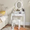 A white vanity table with a stool and mirror in a bedroom setting. Voir les images du produit