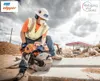 A construction worker is using a concrete saw on a construction site. In the background, there is a gas station under construction. Podgląd zdjęcia produktu