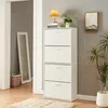 A white shoe cabinet with four flip-down drawers stands in a hallway next to a doorway. A mirror leans against the wall in the doorway, and a basket sits near it. A lamp and a plant are on top of the cabinet. Anteprima dell’immagine prodotto