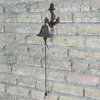 A cast iron anchor-shaped bell mounted on a brick wall. Podgląd zdjęcia produktu
