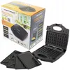The image shows the packaging of a sandwich maker, along with the sandwich maker itself and its interchangeable plates. Náhled obrázku produktu