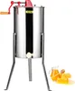 A stainless steel honey extractor with a red handle and a yellow VEVOR logo, shown on a white background with a small pitcher of honey and honeycomb in the foreground. Podgląd zdjęcia produktu