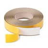 A roll of self-adhesive beige PVC trim with yellow protective backing paper partially peeled away, shown against a white background. Produktbild-Vorschau