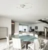A modern dining room and living room area with a glass-top dining table and chairs, a sofa, and a staircase. Produktbild-Vorschau