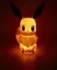 A glowing Eevee figurine is shown against a dark red background. Náhľad obrázku produktu