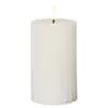 A white LED candle with a ribbed texture and a flame-shaped light. Podgląd zdjęcia produktu