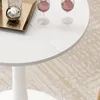 A close-up view of a white round dining table with two glasses of red wine and a decorative silver ball on a tray. Anteprima dell’immagine prodotto