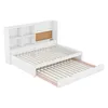 A white wooden bed frame with a pull-out trundle bed and a headboard with shelves and a corkboard. Produktbild-Vorschau