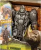 A toy action figure in its packaging, with a rhinoceros horn visible in the foreground. Anteprima dell’immagine prodotto