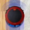 A red and black robot vacuum cleaner is shown on a floor that transitions from wood to tile, with blue arcs indicating its cleaning range. Produktbild-Vorschau