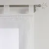 A close-up view of a white sheer curtain with tab tops hanging from a metal curtain rod. Produktbild-Vorschau