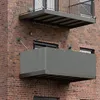Two balconies attached to a brick building. The lower balcony has a gray privacy screen. Produktbild-Vorschau