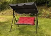 A red and gray cushion set for a garden swing is placed on a grassy lawn. Produktbild-Vorschau