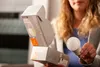 A person is holding a smart light bulb and its packaging. Produktbild-Vorschau