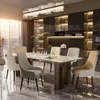 A modern dining room with a marble-top dining table and upholstered chairs, set against a backdrop of sleek kitchen cabinetry and shelves. Voir les images du produit