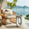 A stylish outdoor seating area with a rattan chair, cushions, and a modern side table, overlooking a scenic ocean view. Náhled obrázku produktu