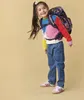 A young girl wearing a backpack and smiling. Náhľad obrázku produktu
