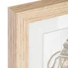 A close-up view of a wooden picture frame with a white matting, revealing a glimpse of a decorative lantern inside. Produktbild-Vorschau