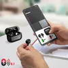 A person is holding a smartphone displaying an app interface, with a pair of black wireless earbuds and their charging case in the foreground. Voir les images du produit