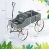 A diagram showing the dimensions of a wooden garden cart with metal wheels. Voir les images du produit