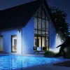 A person is running away from a house with a swimming pool at night, illuminated by motion-sensor lights. Produktbild-Vorschau