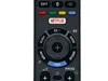A close-up view of a black remote control with various buttons. Produktbild-Vorschau