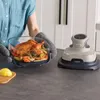 A person is holding a glass baking dish with a roasted chicken and vegetables, next to a Ninja CRISPi air fryer. Anteprima dell’immagine prodotto
