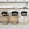 Three black bar stools with gold bases are arranged in front of a kitchen island and cabinetry. Produktbild-Vorschau