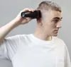 A man is using a hair clipper on his own head. Podgląd zdjęcia produktu
