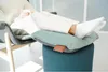 A person relaxing in a chair with their feet up on a stool with cushions. Produktbild-Vorschau