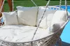 A hanging chair with cushions next to a swimming pool. Produktbild-Vorschau